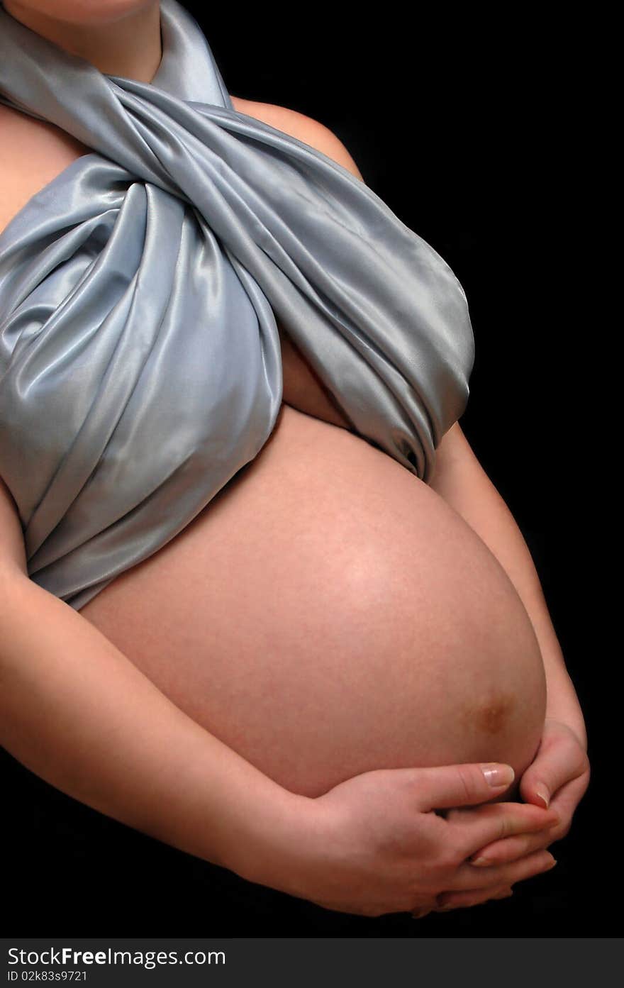 Pregnant woman belly isolated on black