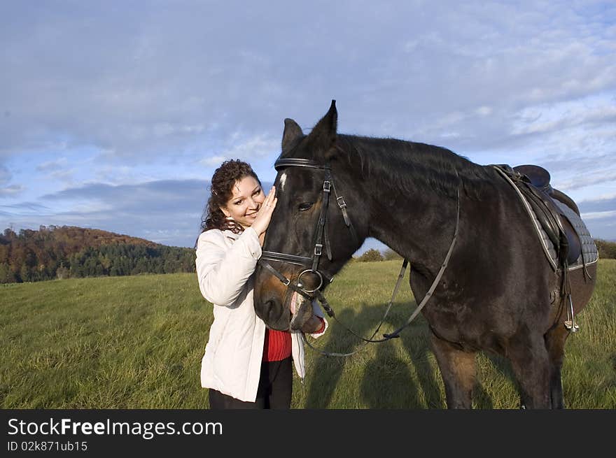 Equestrienne  strokes a horse.