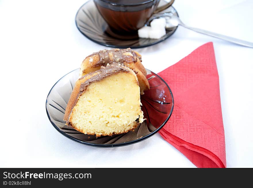 Sweet marble cake on plate with tea and red napkin