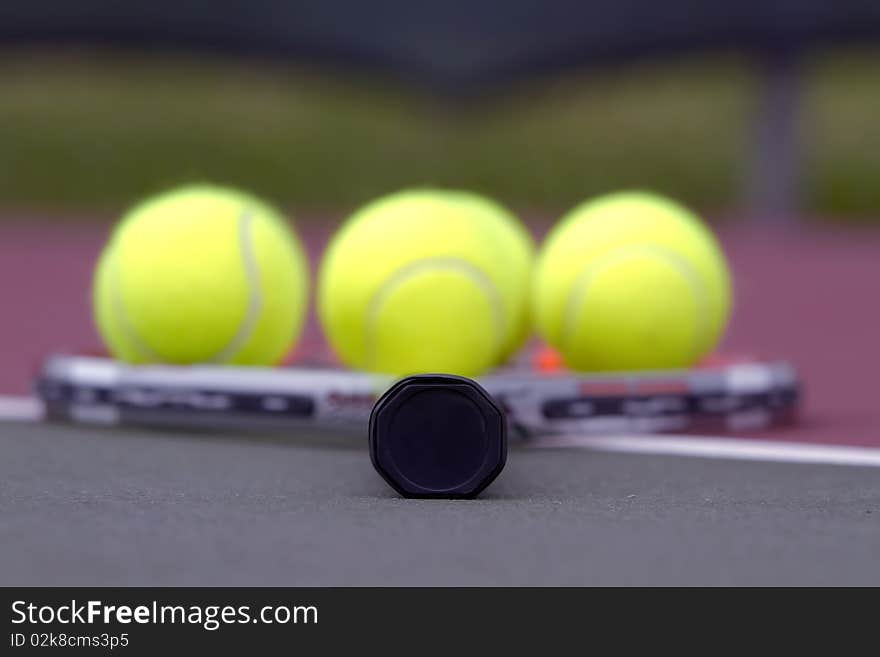 Tennis balls on a racket on the court ground. Tennis balls on a racket on the court ground.