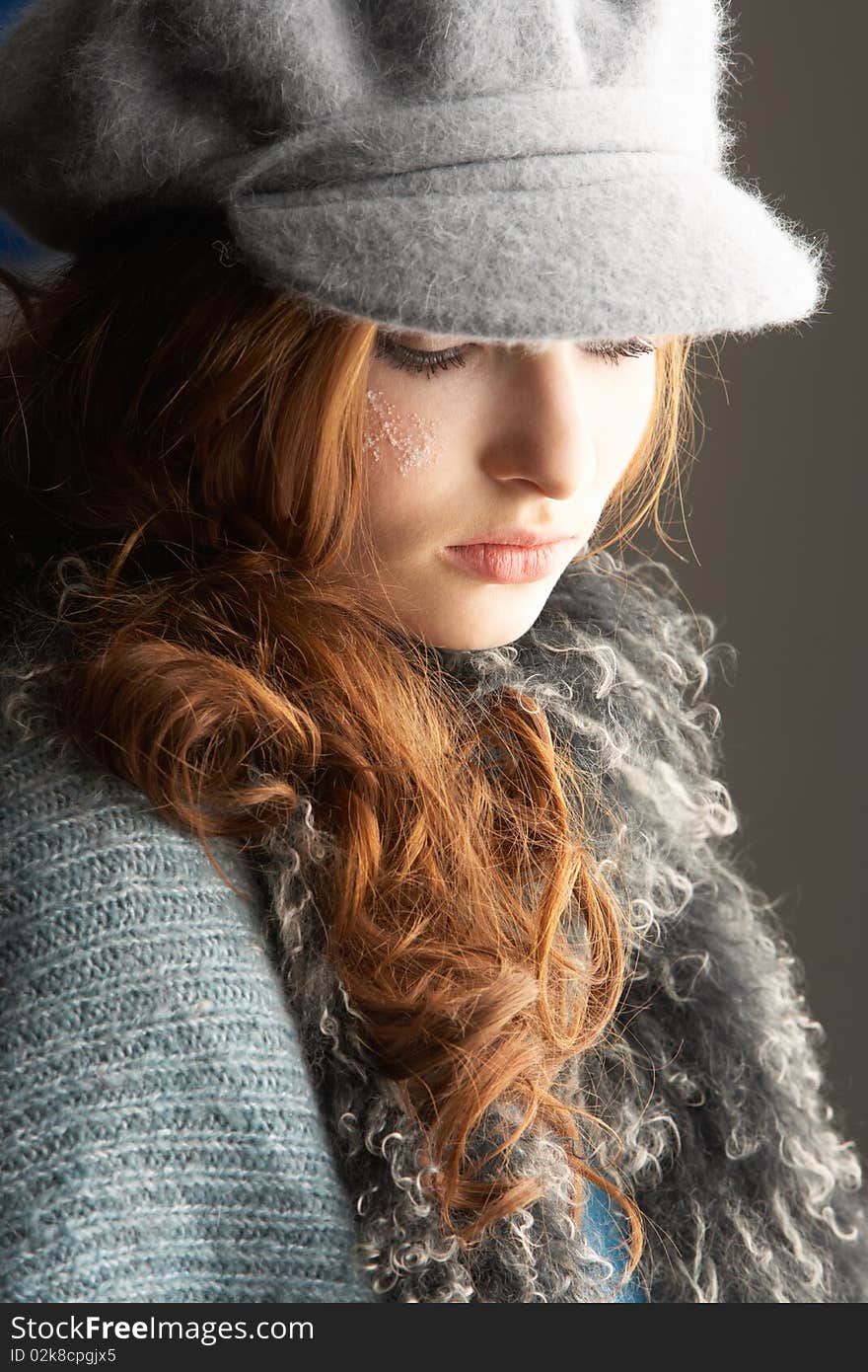 Teenage Girl Wearing Cap And Knitwear In Studio