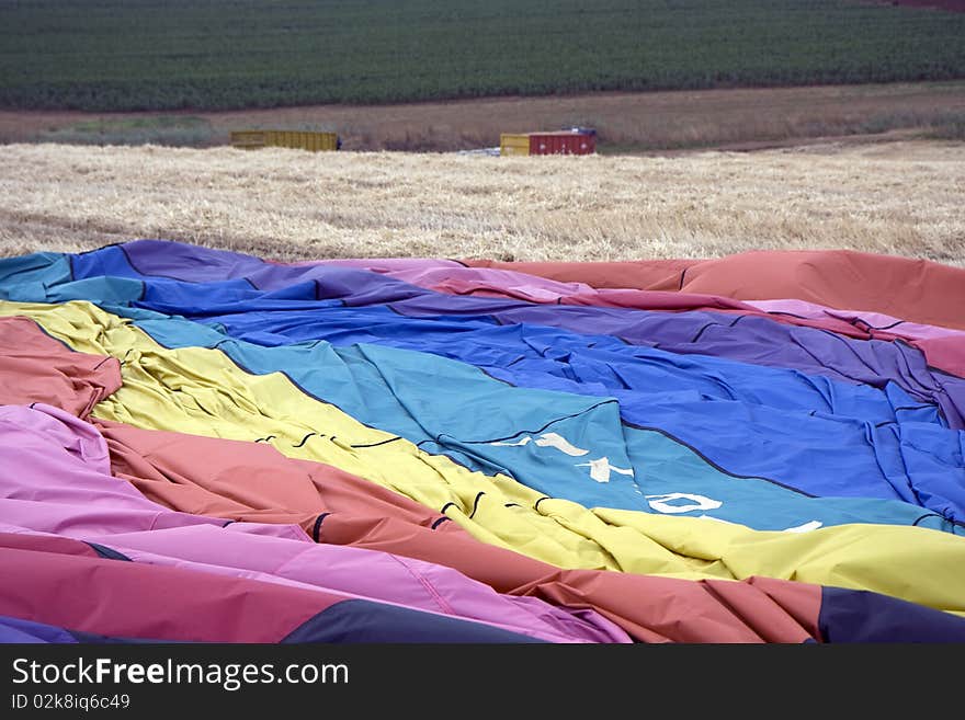 Hot air balloon laying in the field