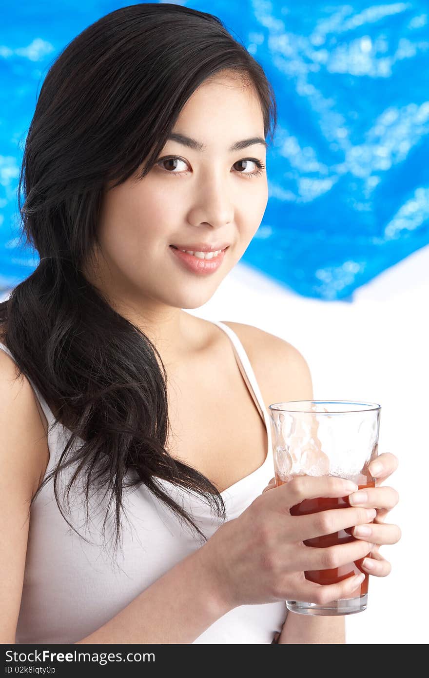 Young Woman Enjoying Healthy Drink In Studio At Camera