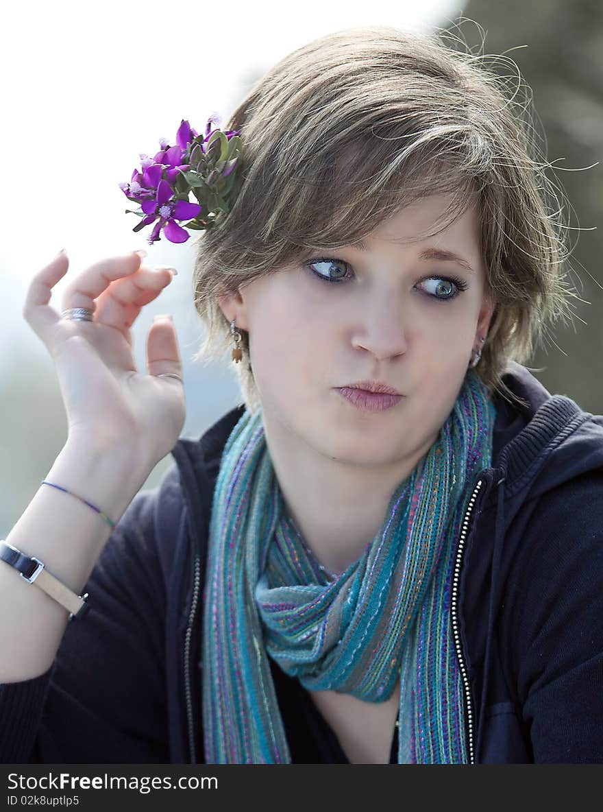 Blonde putting flowers in her hair, her hand with long nails and treated. Blonde putting flowers in her hair, her hand with long nails and treated