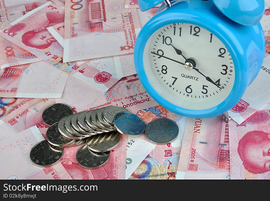 A blue clock with a lot of money note and coins, means time have relative with fortune and rich, or time is value and cost. A blue clock with a lot of money note and coins, means time have relative with fortune and rich, or time is value and cost.