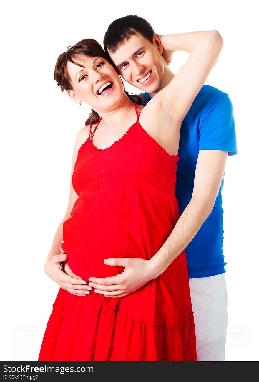 Young happy pregnant woman and her husband embracing and laughing