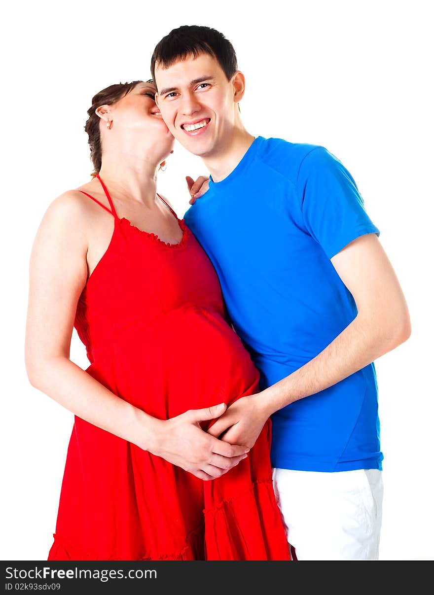 Young happy pregnant woman and her husband embracing and kissing