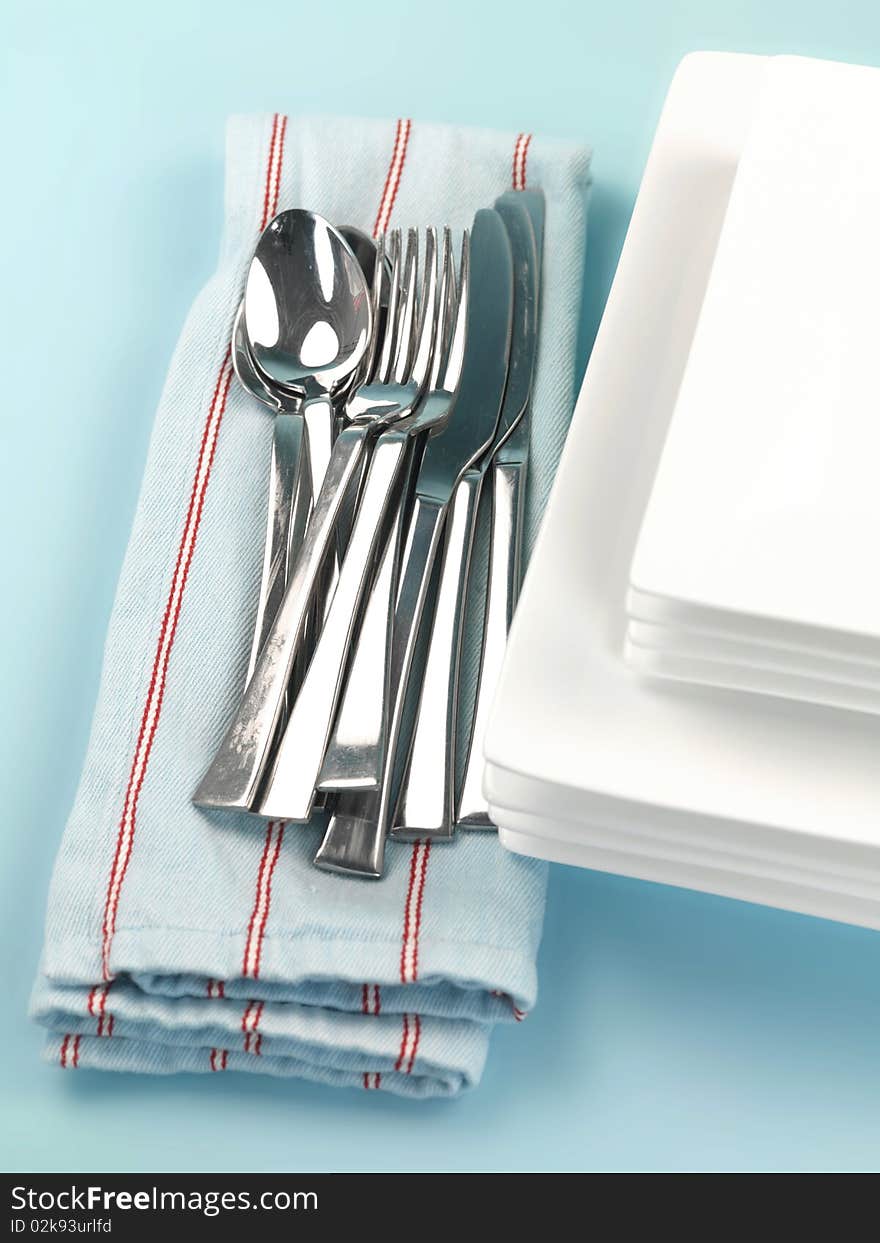 Plates and cutlery isolated against a blue background