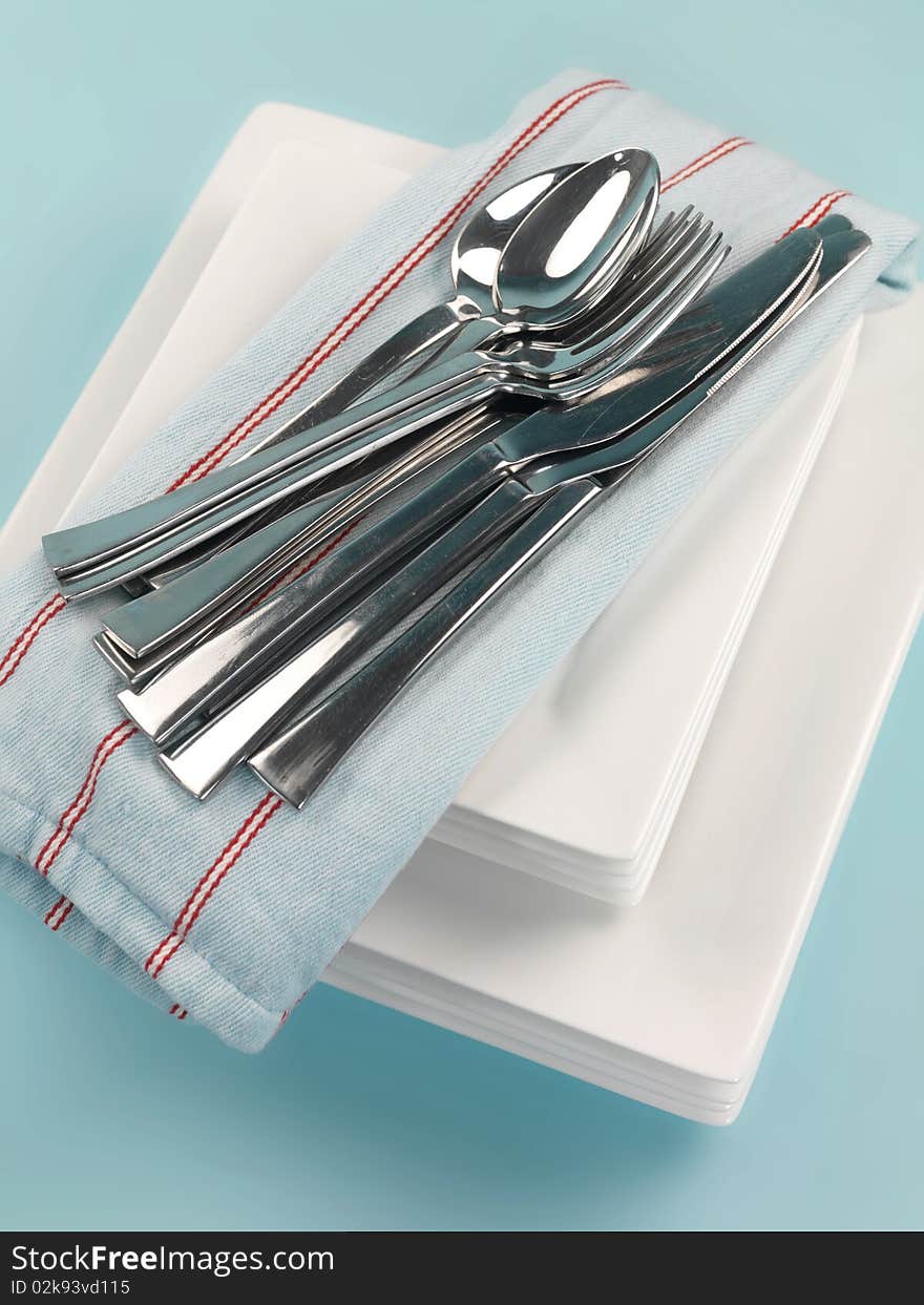 Plates and cutlery isolated against a blue background