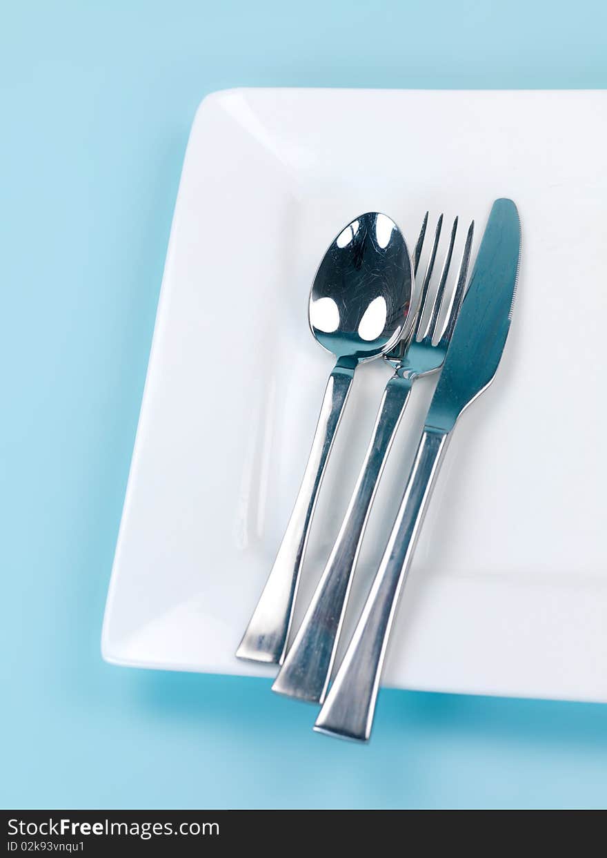 Plates and cutlery isolated against a blue background