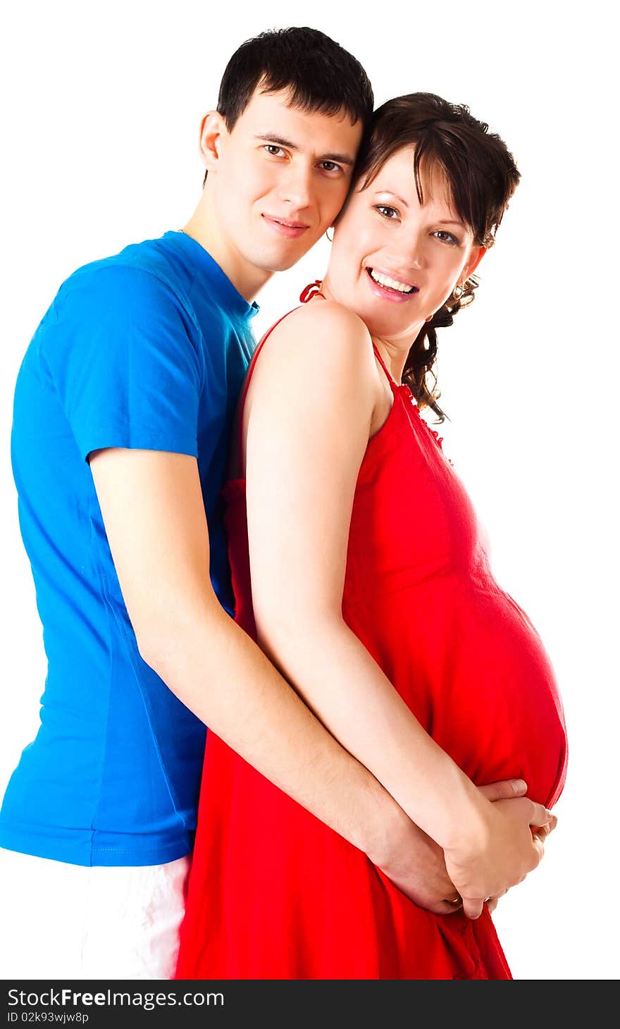 Young happy pregnant woman and her husband embracing and laughing