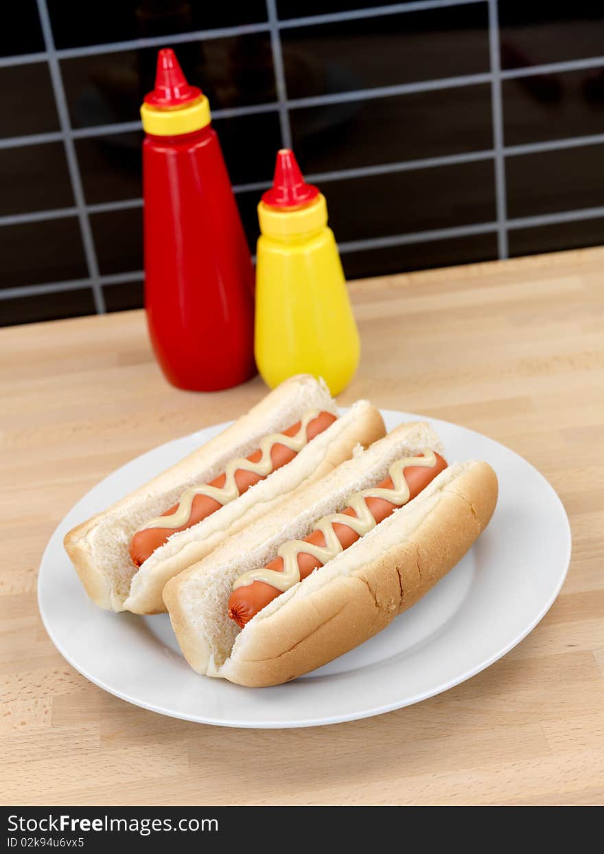 A hotdog with mustard sauce on a kitchen bench. A hotdog with mustard sauce on a kitchen bench