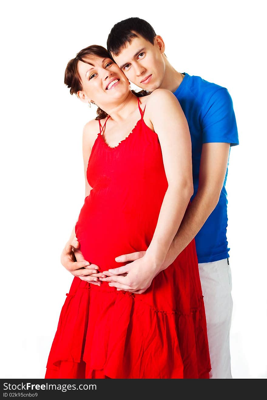 Young happy pregnant woman and her husband embracing and laughing