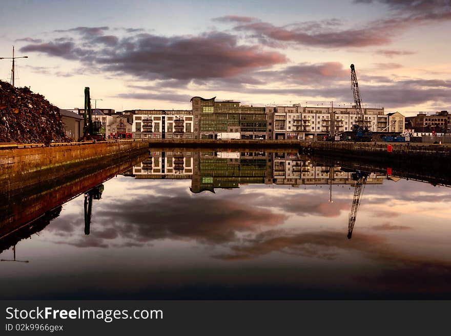 Morning vew on row of buildings and industrial area at Galway Dock with skys reflected in the water, HDR. Morning vew on row of buildings and industrial area at Galway Dock with skys reflected in the water, HDR