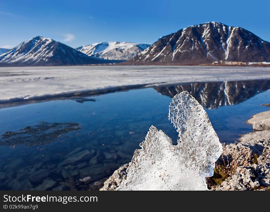 Big piece of ice on coast of lake in mountains. Big piece of ice on coast of lake in mountains