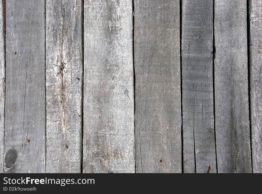 Fragment of an old wooden wall from boards with rusty nails