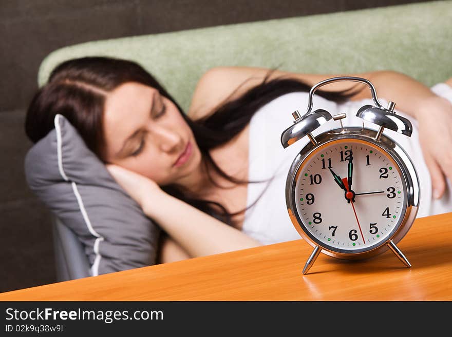 Vintage alarm clock, with beautiful young woman sleeping in the background. Vintage alarm clock, with beautiful young woman sleeping in the background