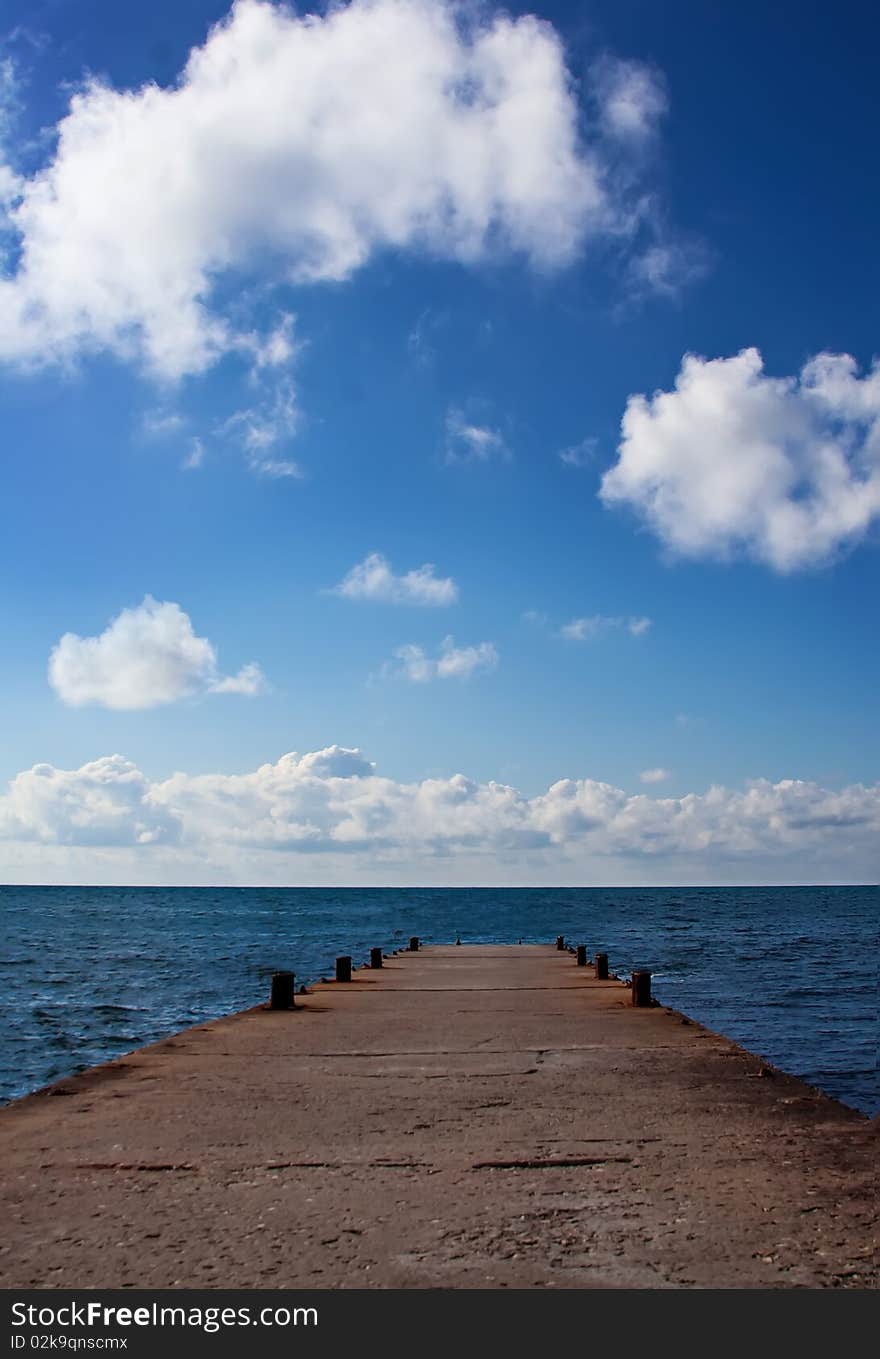 View over thesea far below, white clouds and pier. View over thesea far below, white clouds and pier