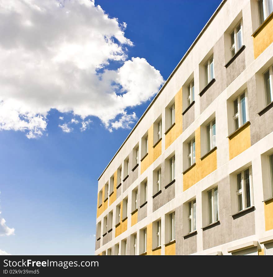 Yellow building with windows over blue sky