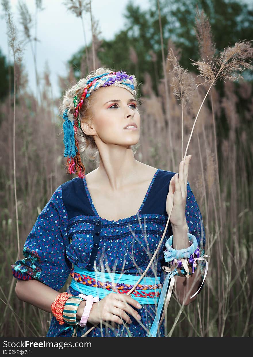 Beautiful young woman standing on yellow grass