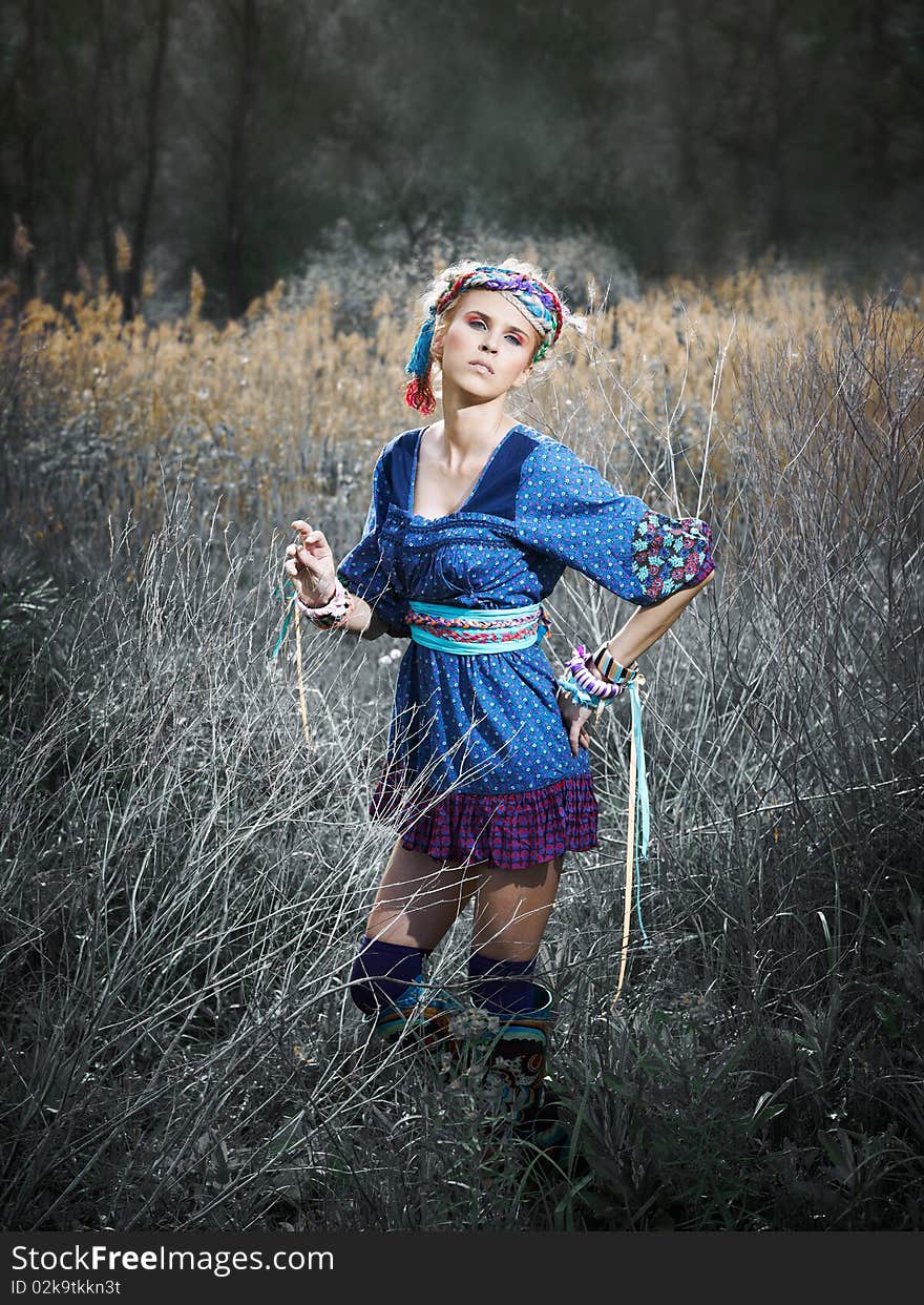 Beautiful young woman standing on yellow grass