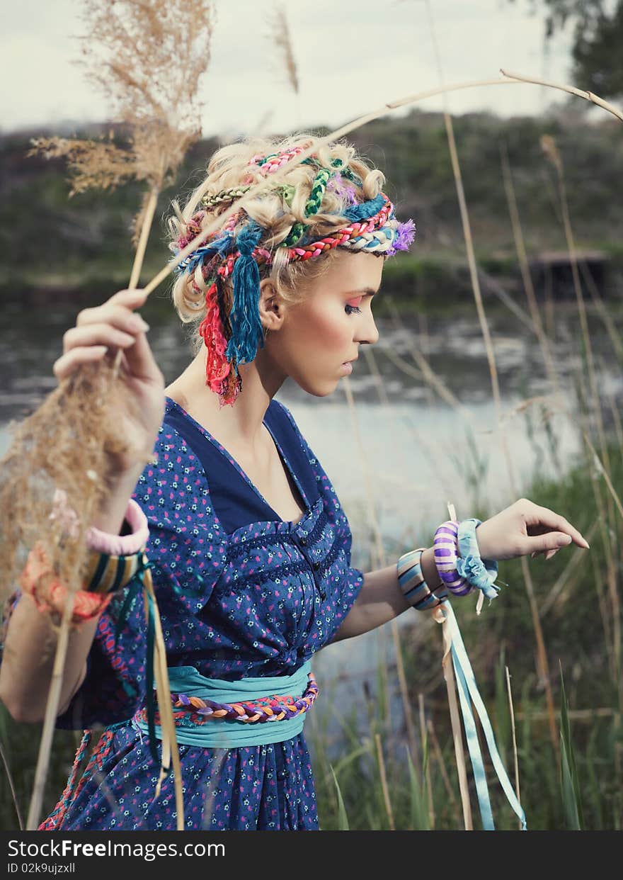 Beautiful young woman standing on yellow grass