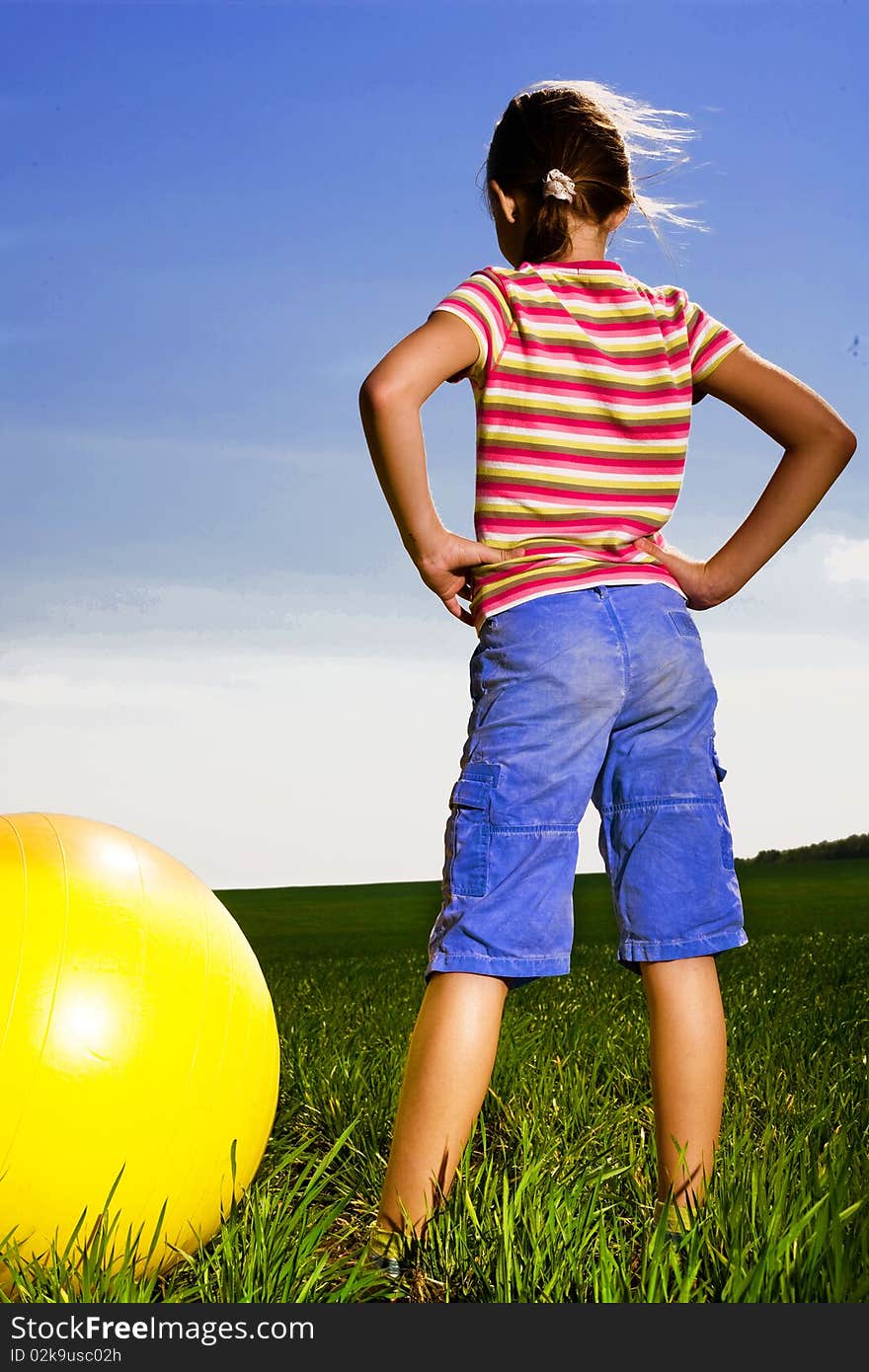 Girl with yellow ball in field. Girl with yellow ball in field