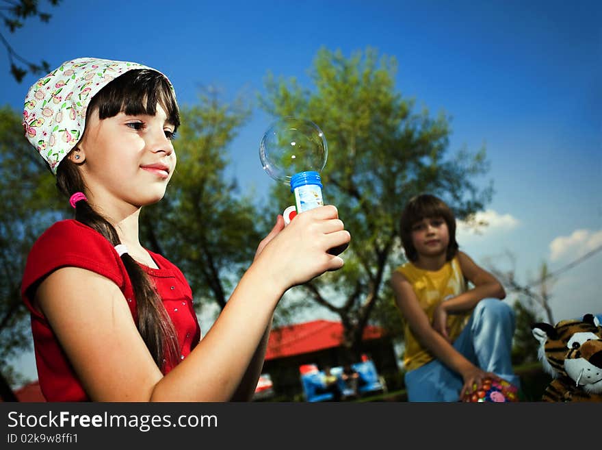 Nice girl with soap bubbles in park