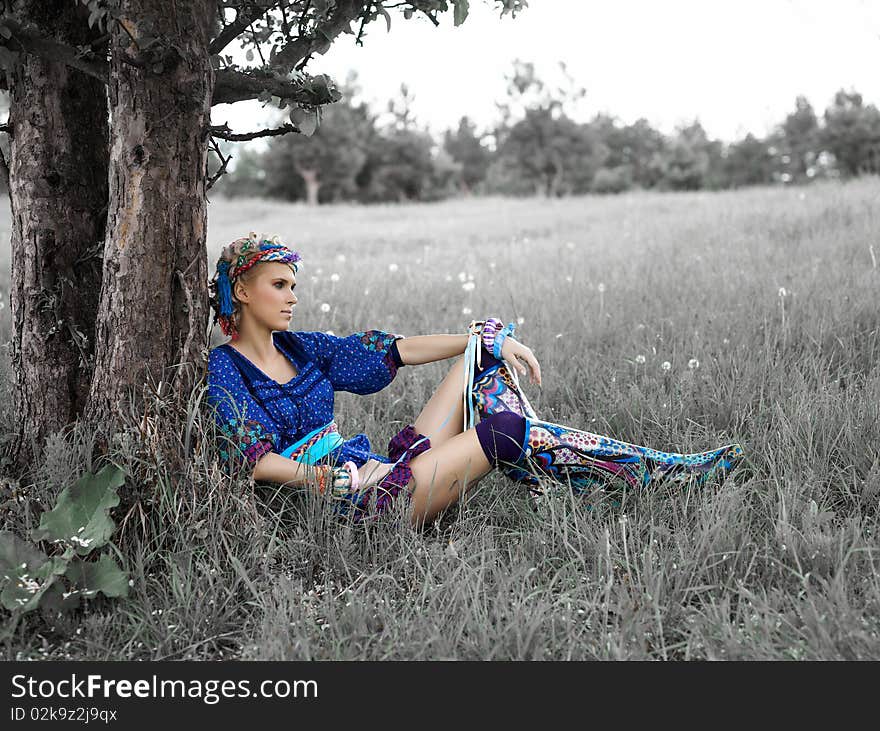 Beautiful young woman sitting on the grass