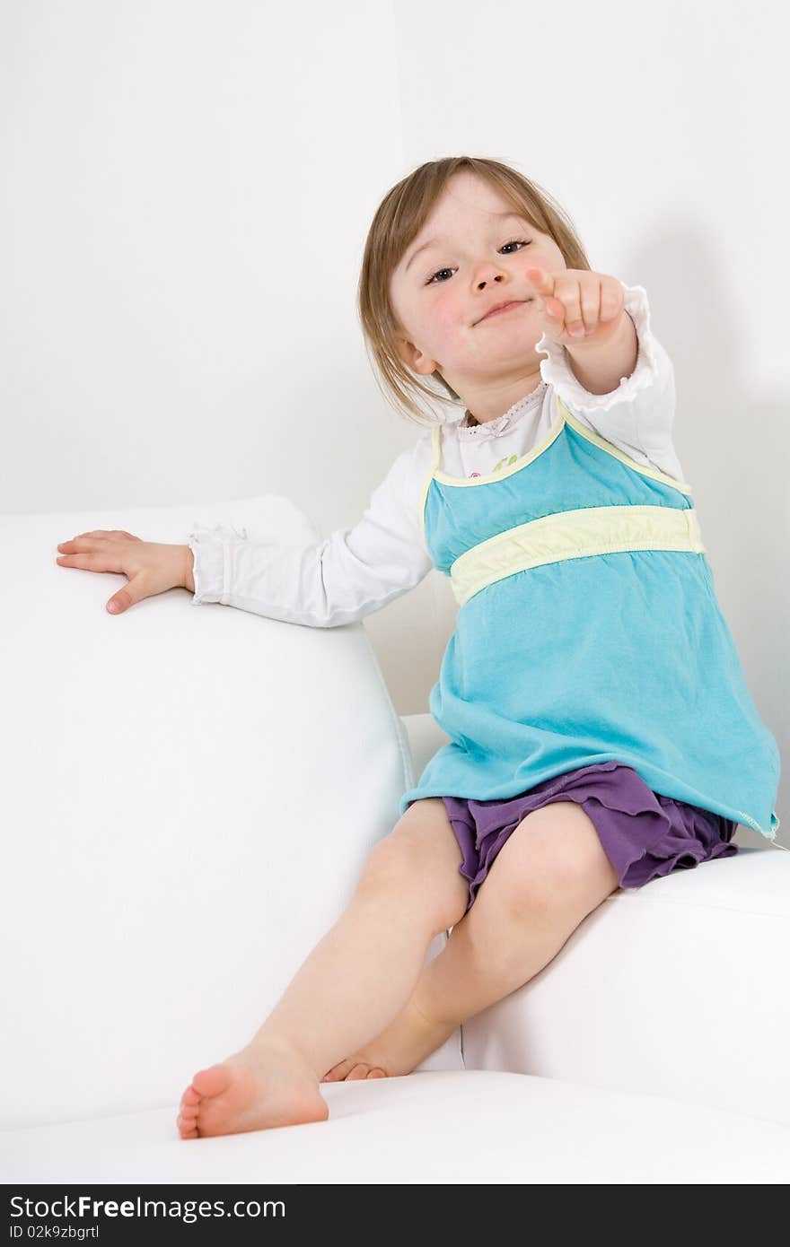 Sweet happy little girl on sofa