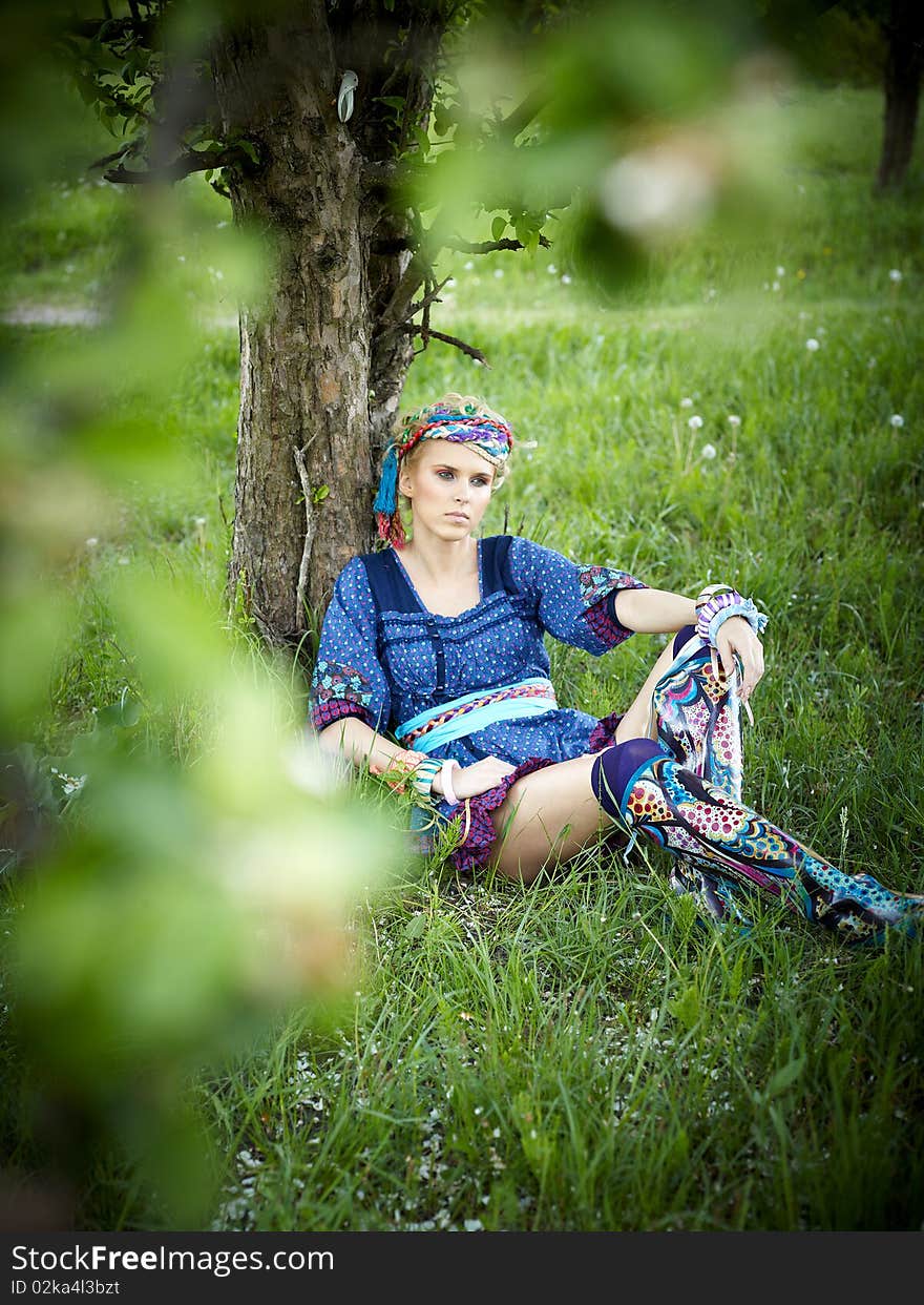 Beautiful young woman sitting on the grass