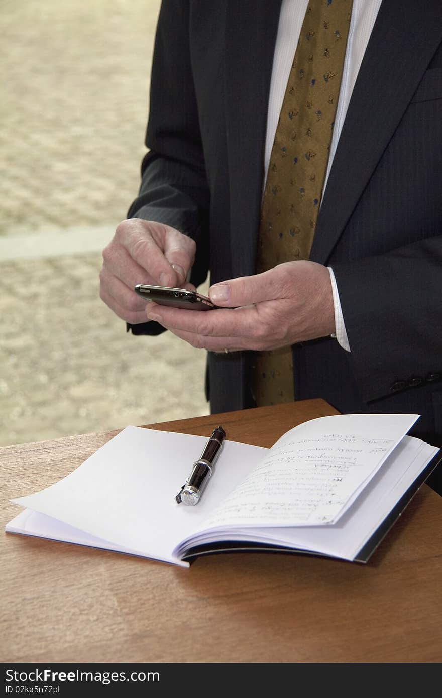 Well dressed business man with cell phone and calendar.