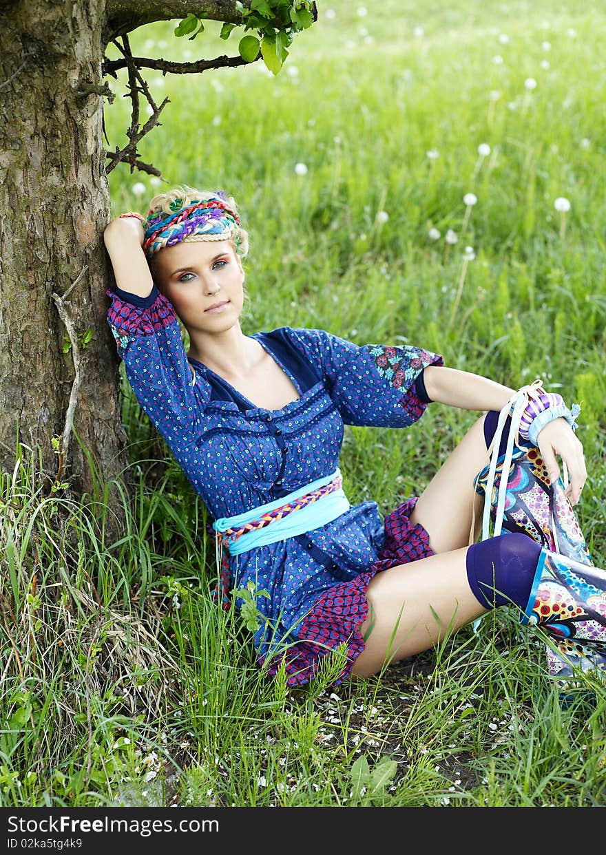 Beautiful young woman sitting on the grass