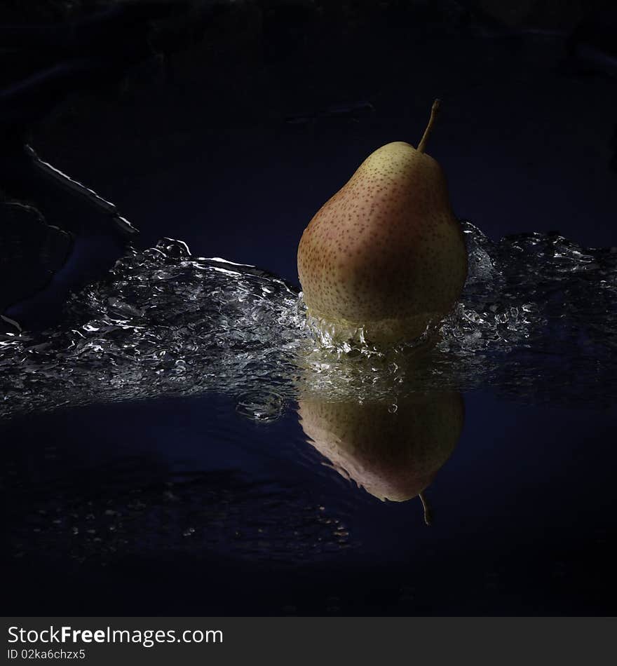 Pear with teflection in water splash studio shot. Pear with teflection in water splash studio shot