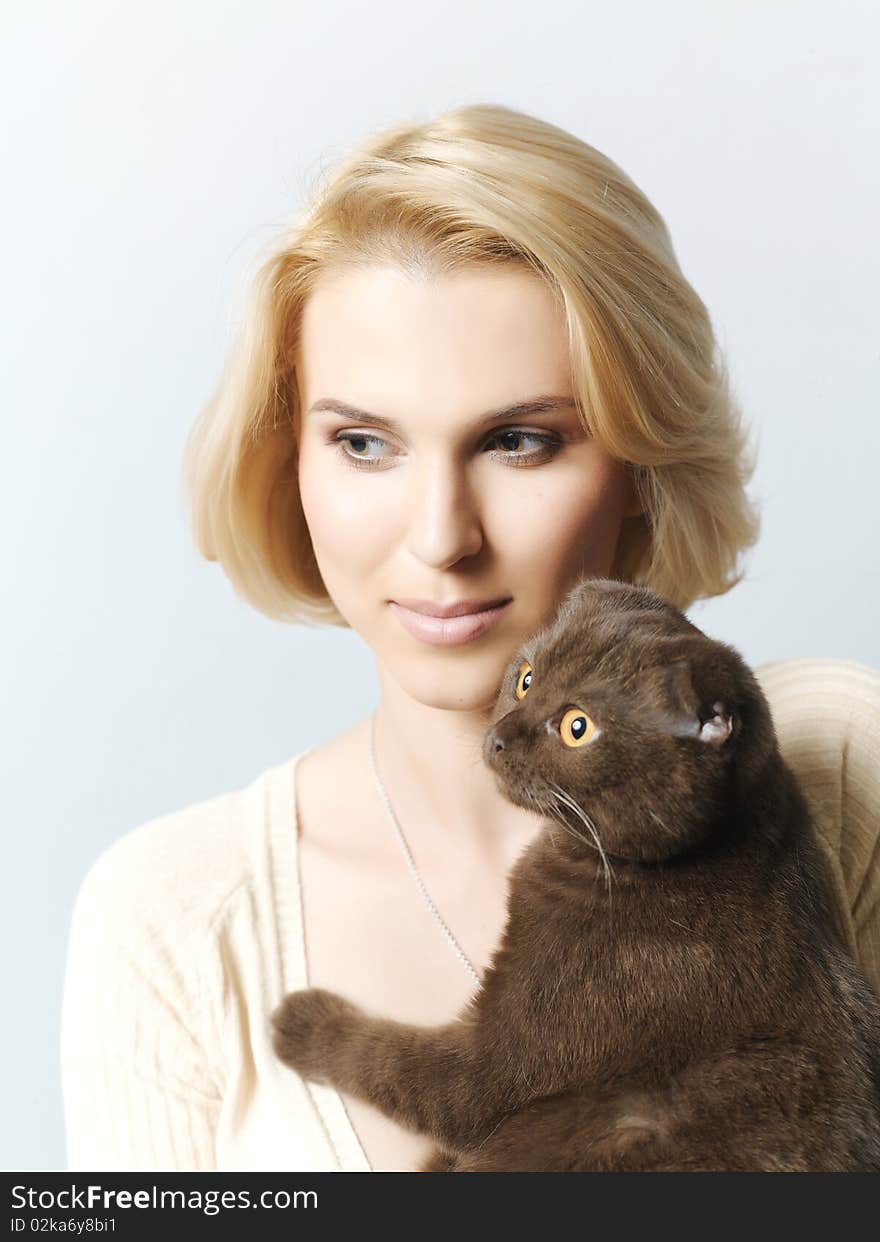 Beautiful young woman keeping a cat in the hands