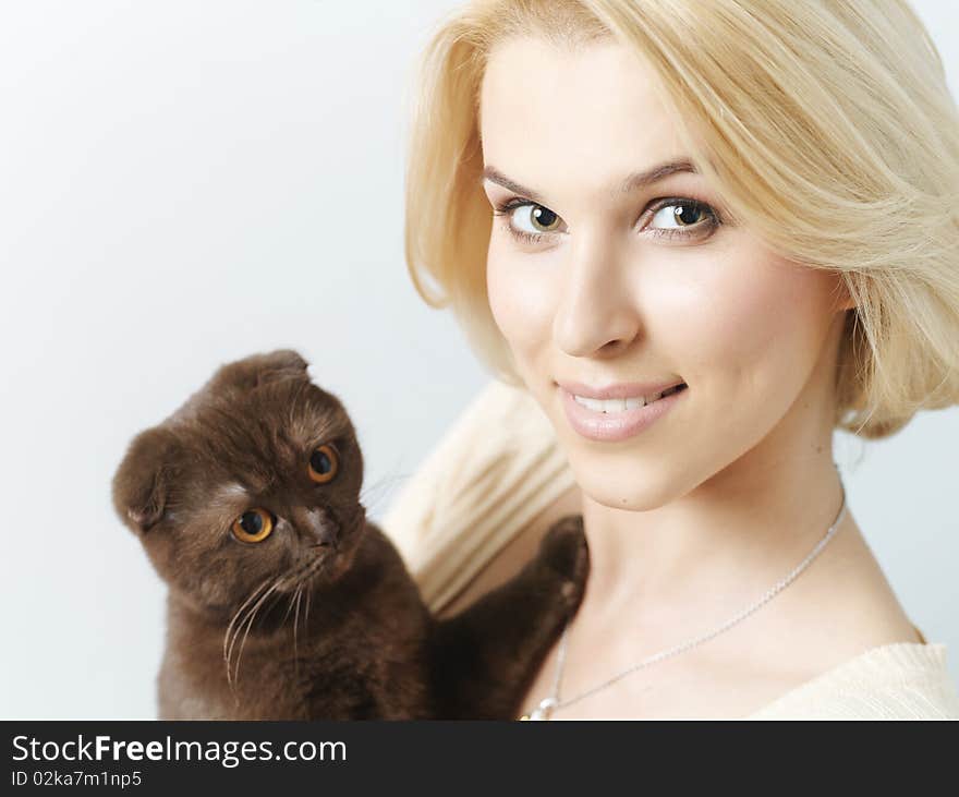 Beautiful young woman keeping a cat in the hands