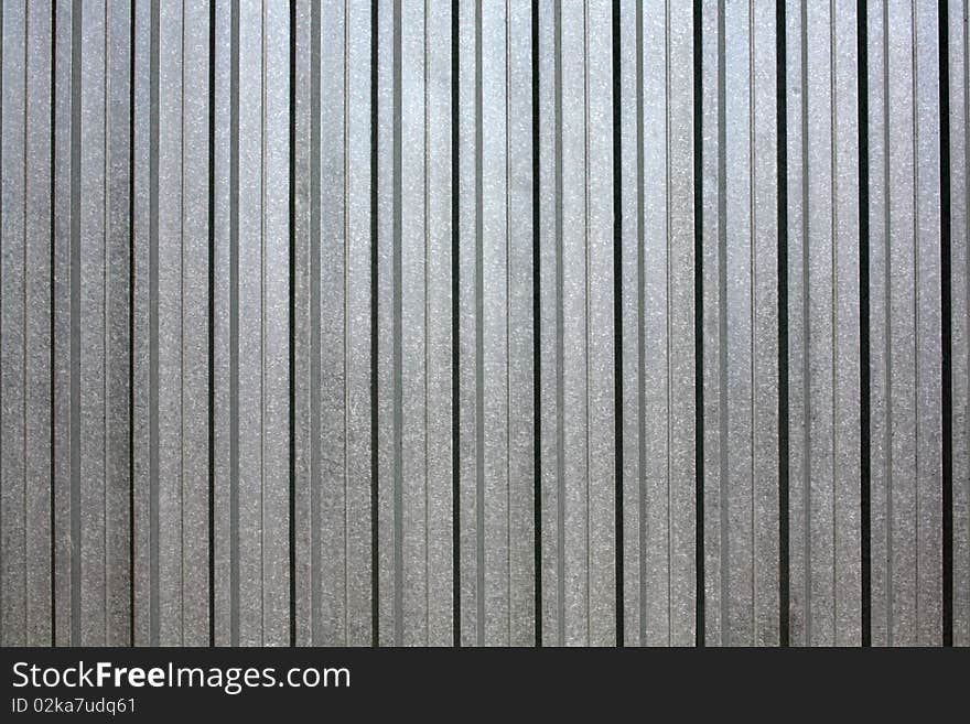 Corrugated, silvery iron, grey colour. Corrugated, silvery iron, grey colour