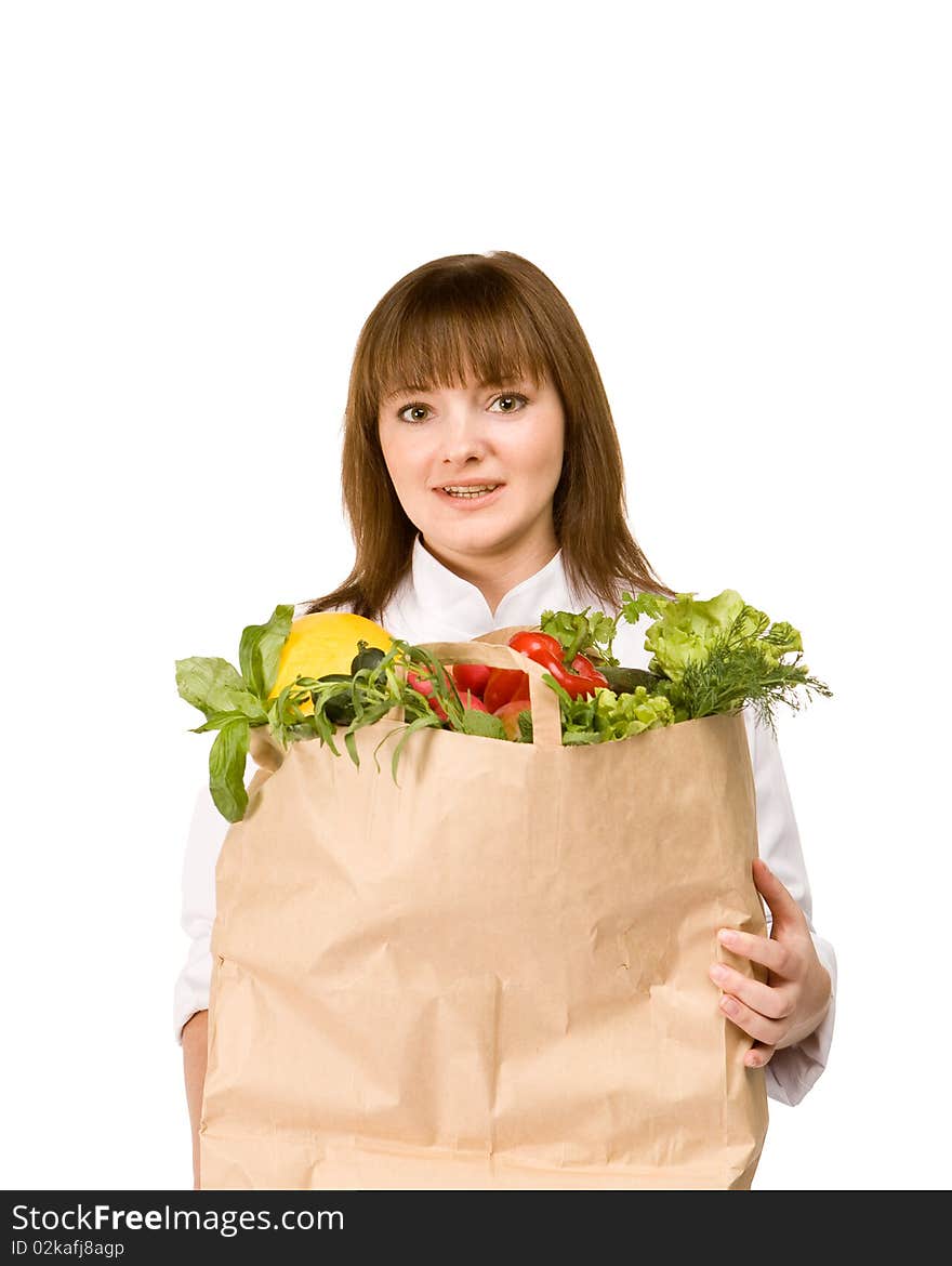 Cook girl holding a paper bag with vegetables - isolated on white