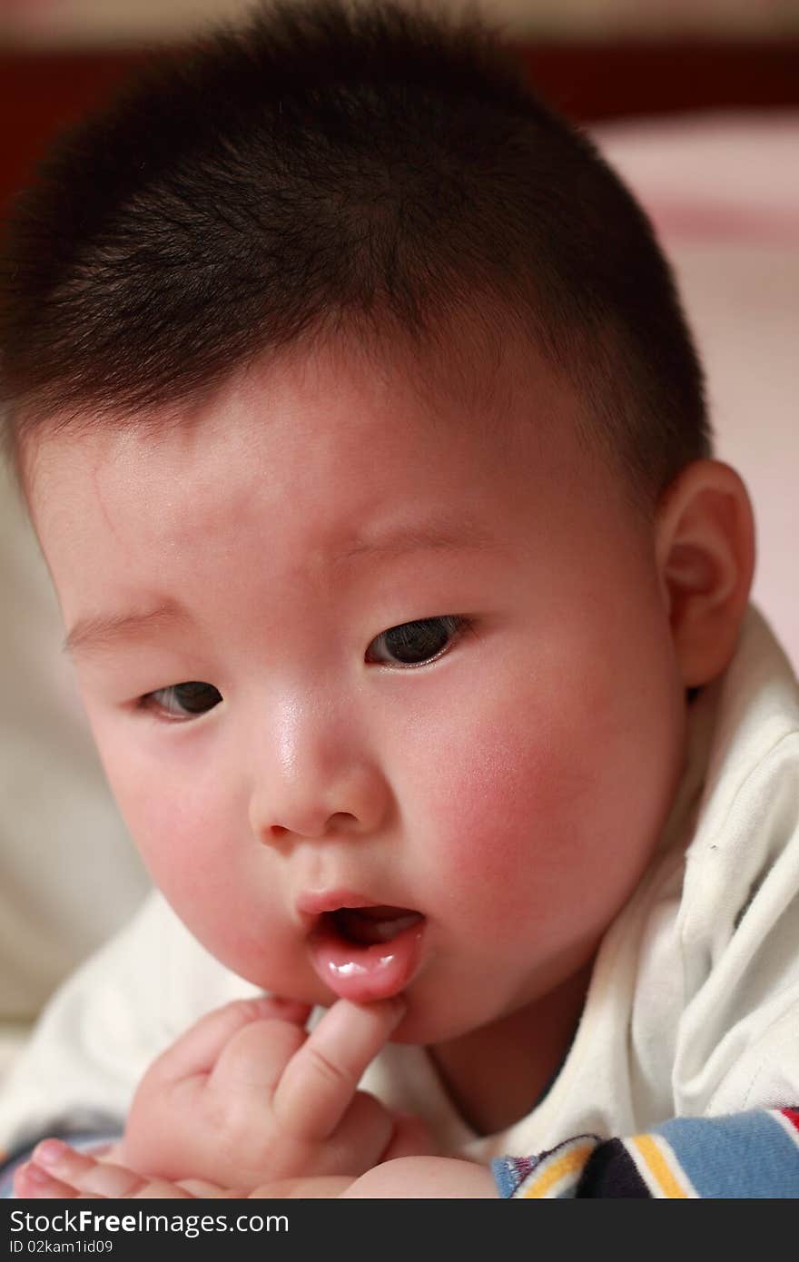 Lovely Chinese baby is playing in the bed