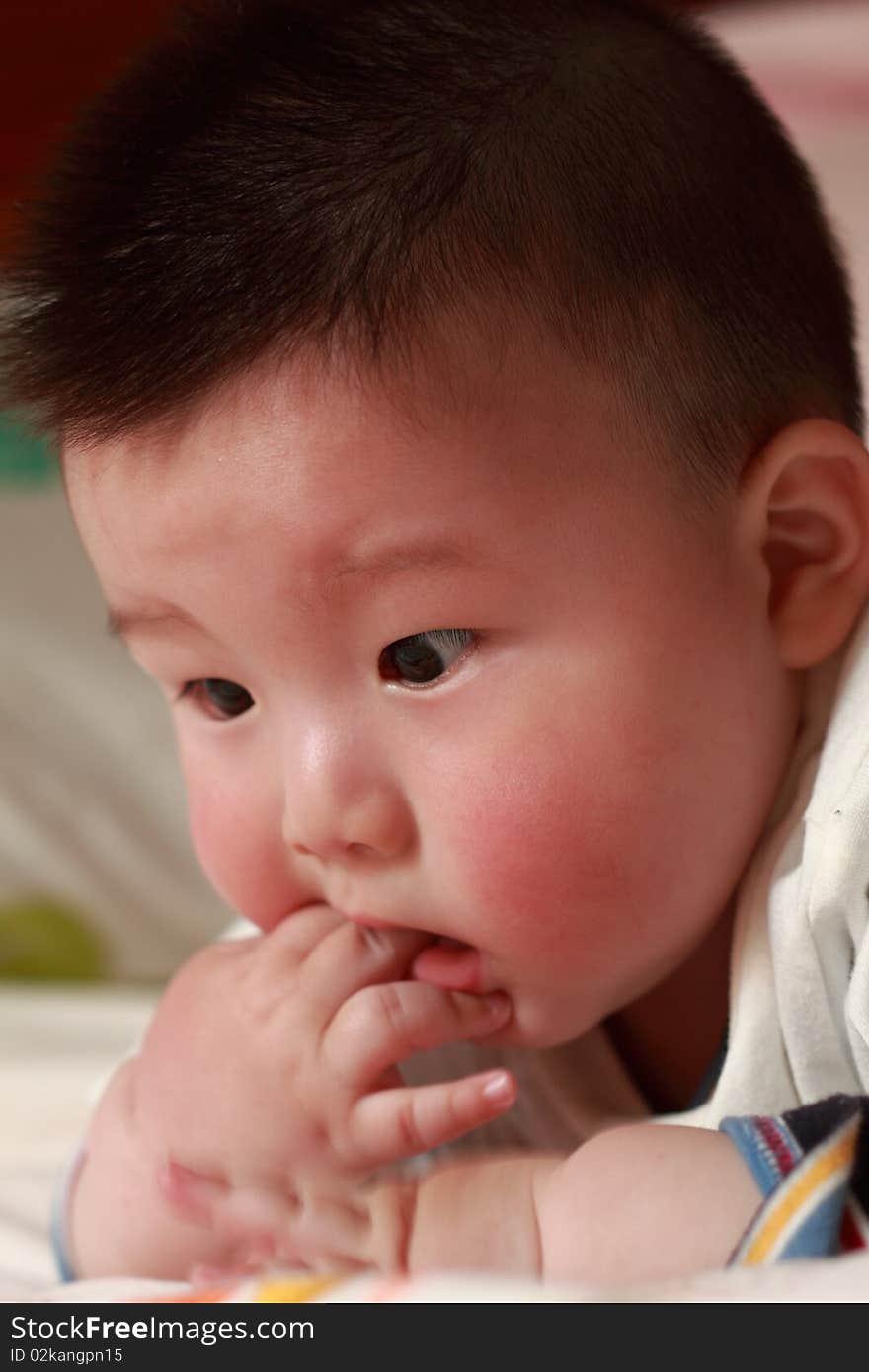 Lovely Chinese baby is playing in the bed. Lovely Chinese baby is playing in the bed