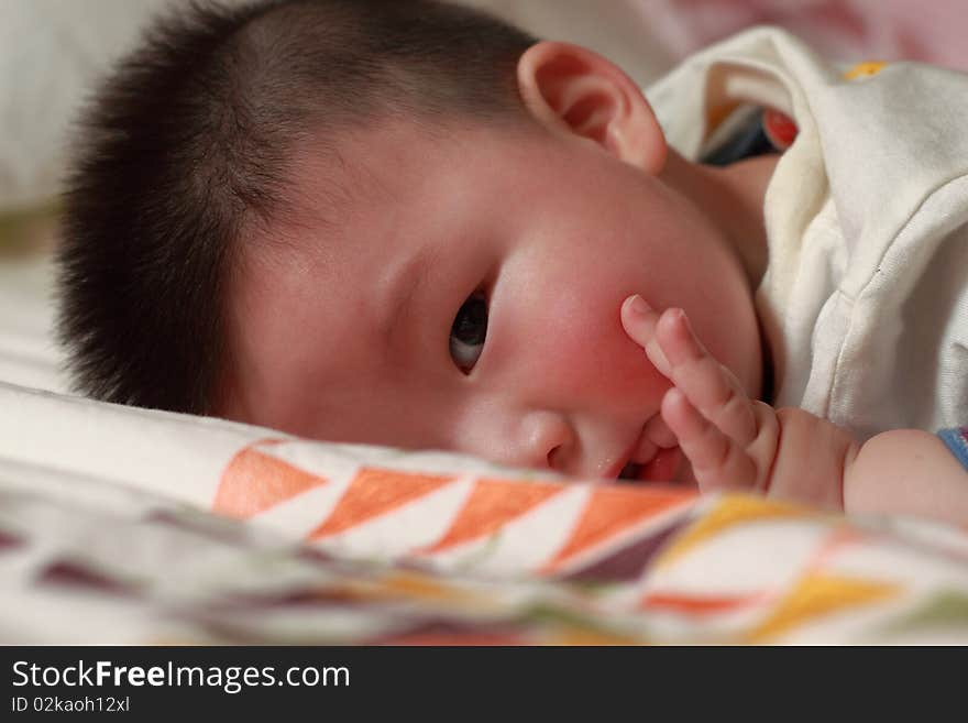 Lovely Chinese baby is playing in the bed