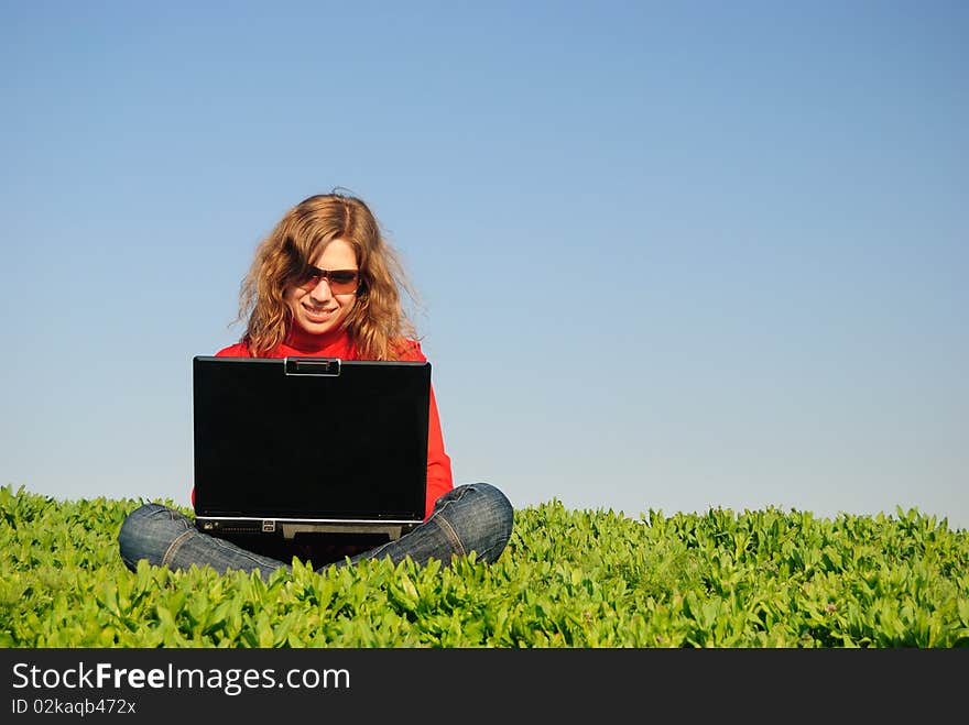 The beautiful girl with the laptop in the field. The beautiful girl with the laptop in the field