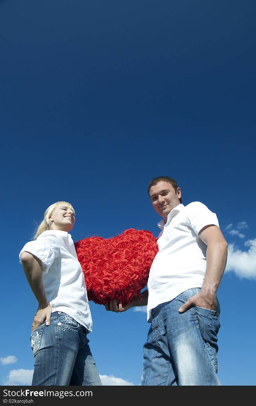 Couple of young people, loving boy and girl holding hands in the heart of roses. Couple of young people, loving boy and girl holding hands in the heart of roses