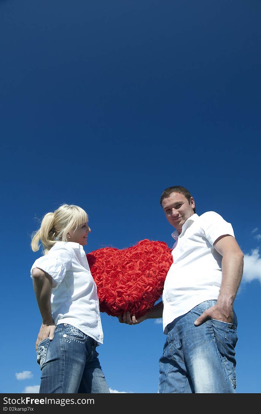 Couple of young people, loving boy and girl holding hands in the heart of roses. Couple of young people, loving boy and girl holding hands in the heart of roses