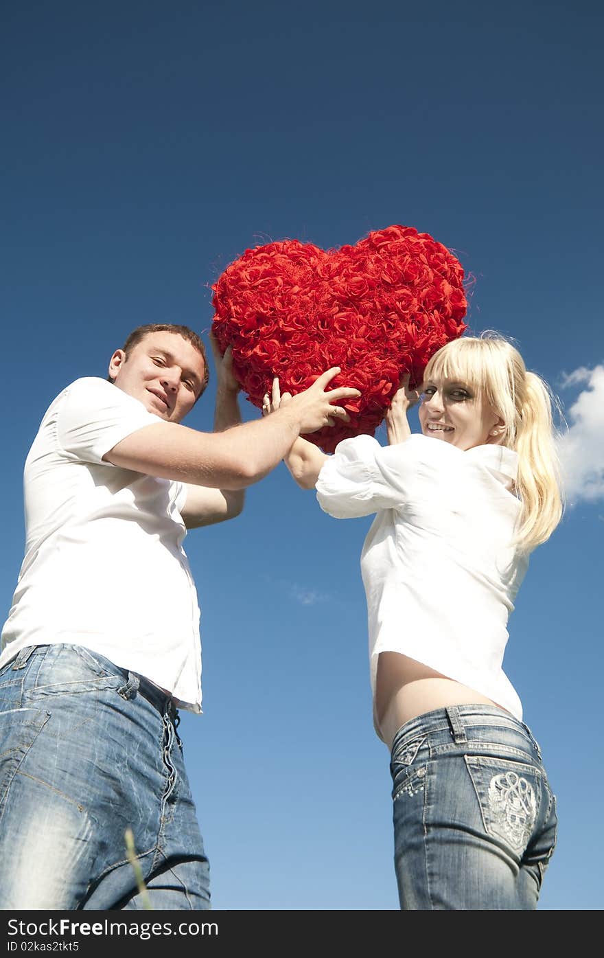 Couple of young people, loving boy and girl holding hands in the heart of roses. Couple of young people, loving boy and girl holding hands in the heart of roses