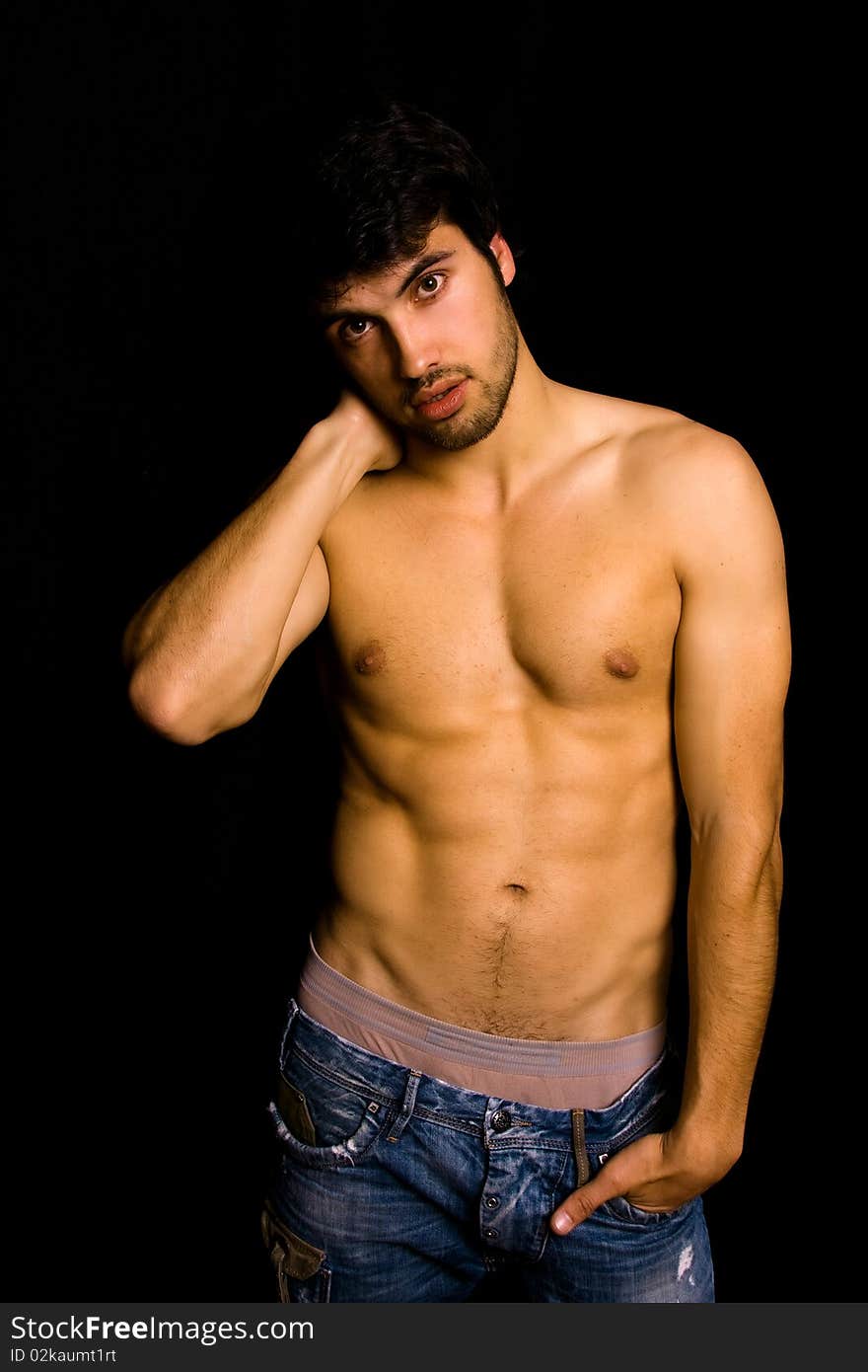 Young man with atletic body on black background