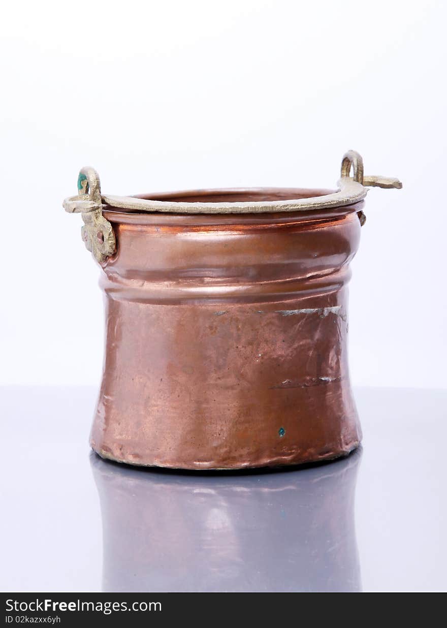 Brass container over glass and white background