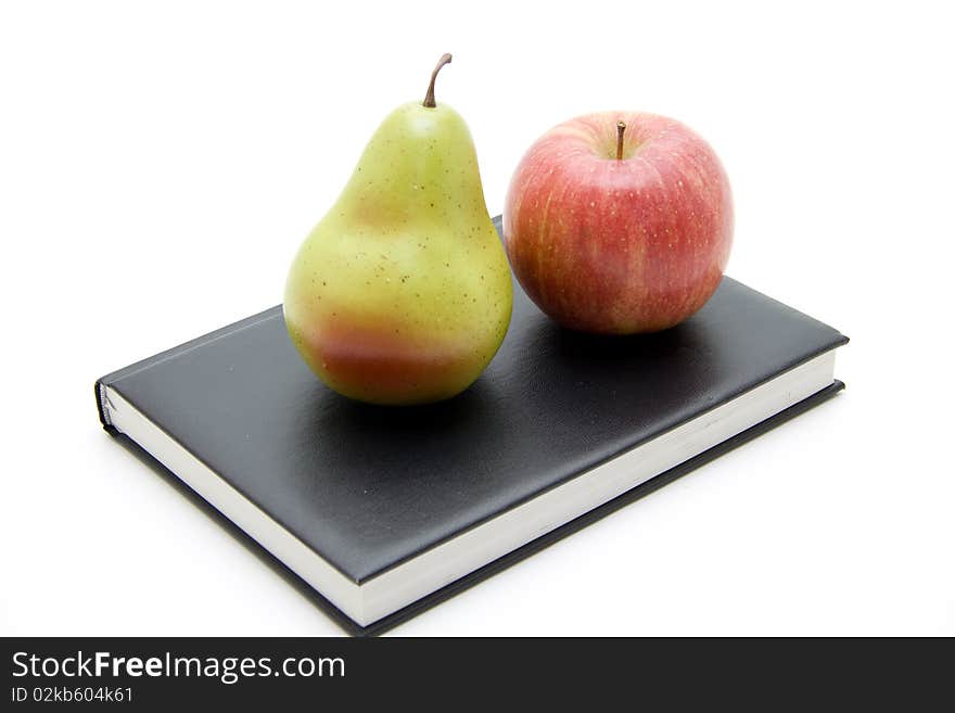 Apple and pear on black book. Apple and pear on black book