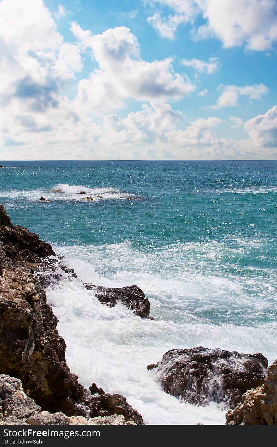 Blue sea with clouds, stones and rocks