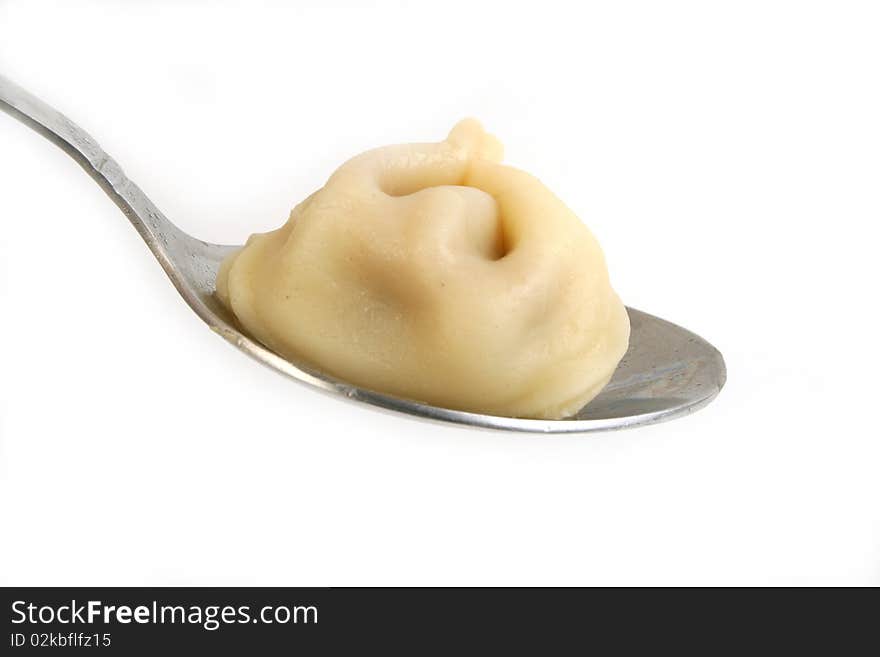 Ravioli in spoon close-up on white background